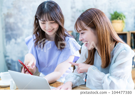 Two young women planning a trip 104477380