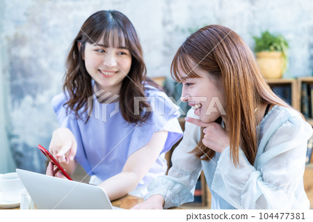Two young women planning a trip Two young women planning a trip 104477381