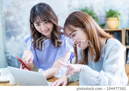 Two young women planning a trip 104477382