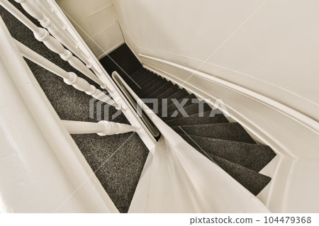 a staircase with black and white carpeting on the bottom, leading up to the second floor in an apartment building 104479368
