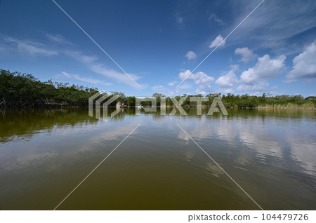 Distant kayaker and fisherman on Nine Mile Pond in Everglades National Park. 104479726
