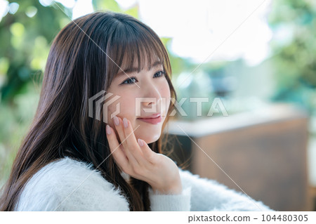 A young woman feels her skin become more moisturized 104480305