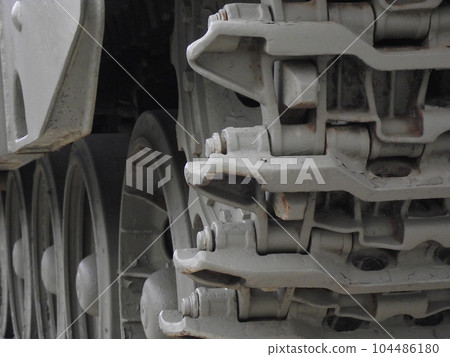 Ultra close-up of the caterpillar track of stationary war tank in an undisclosed location 104486180