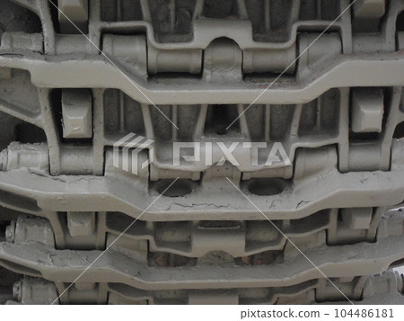 Ultra close-up of the caterpillar track of stationary war tank in an undisclosed location 104486181