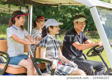 Golfer man and woman riding a golf cart on a golf course 104486207