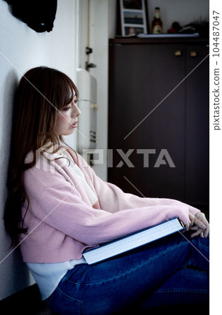 一個女人正在考慮看一本相冊 一個女人正在考慮看一本相冊 104487047