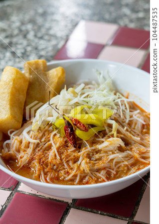 Rice noodles in fish curry sauce with vegetables  104487535