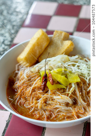 Rice noodles in fish curry sauce with vegetables  104487573