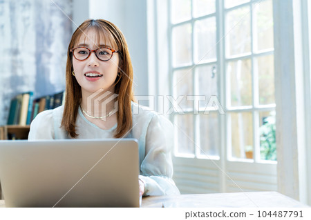 Young woman with glasses using laptop in the room 104487791