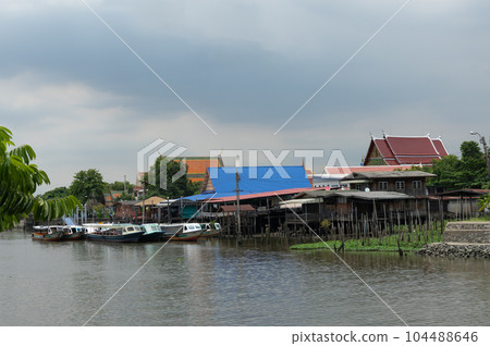 A traditional old house by the river with boats passing by. on creativity A traditional old house by the river with boats passing by. on creativity 104488646