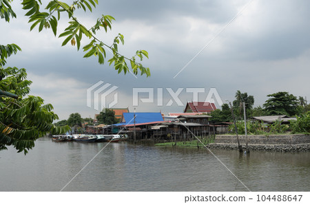 A traditional old house by the river with boats passing by. on creativity 104488647