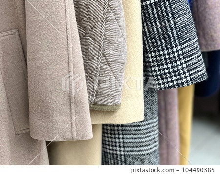 Close-up of coat sleeves lined up in a closet 104490385
