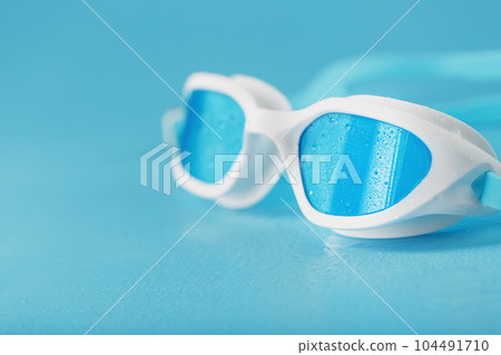 Swimming goggles in a white frame with on a blue background 104491710