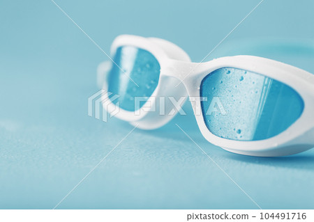 White swimming glasses with a blue lens 104491716