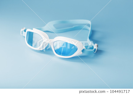 Swimming goggles in a white frame with on a blue background Swimming goggles in a white frame with on a blue background 104491717