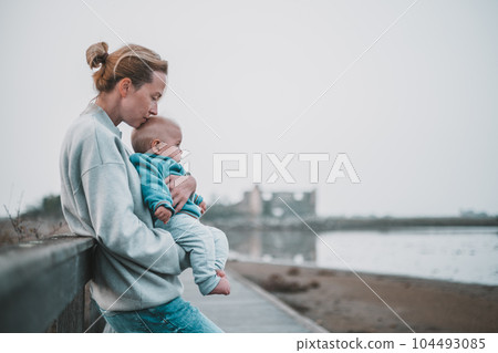 Tender woman caressing her little baby boy infant child outdoors on autumn trip to Secovlje salinas landscape park, Slovenia. Mother's unconditional love for her child Tender woman caressing her little baby boy infant child outdoors on autumn trip to Secovlje salinas landscape park, Slovenia. Mother's unconditional love for her child 104493085