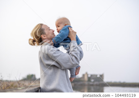 Tender woman caressing her little baby boy infant child outdoors on autumn trip to Secovlje salinas landscape park, Slovenia. Mother's unconditional love for her child Tender woman caressing her little baby boy infant child outdoors on autumn trip to Secovlje salinas landscape park, Slovenia. Mother's unconditional love for her child 104493119