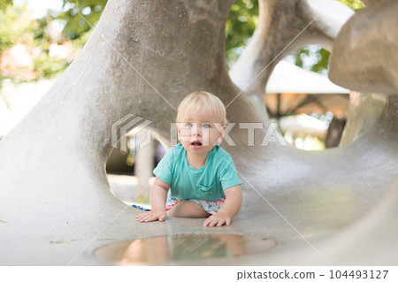 Child playing on outdoor playground. Toddler plays on school or kindergarten yard. Active kid on stone sculpured slide. Healthy summer activity for children. Little boy climbing outdoors Child playing on outdoor playground. Toddler plays on school or kindergarten yard. Active kid on stone sculpured slide. Healthy summer activity for children. Little boy climbing outdoors 104493127