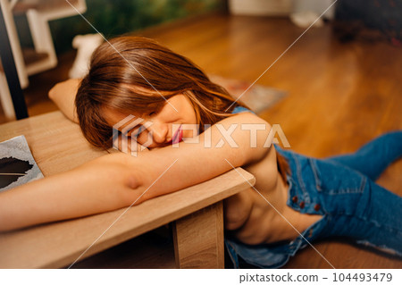 a naked woman in denim jumpsuit lying on the floor near the coffee table a naked woman in denim jumpsuit lying on the floor near the coffee table 104493479