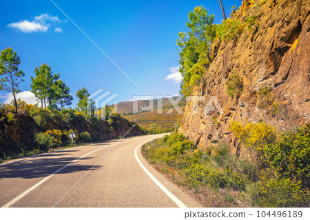 View of beautiful mountain landscape through the windscreen on a sunny day. Driving a car on mountain winding road. Spain, Europe View of beautiful mountain landscape through the windscreen on a sunny day. Driving a car on mountain winding road. Spain, Europe 104496189