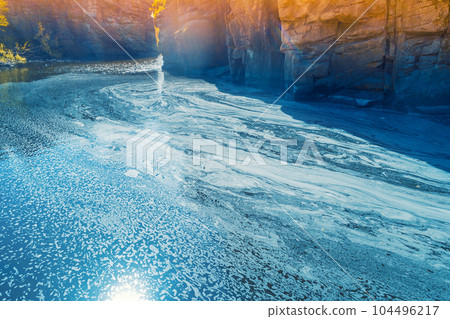 Mountain landscape. Aerial view of a mountain river in early spring. Abstract pattern of foam on the water 104496217