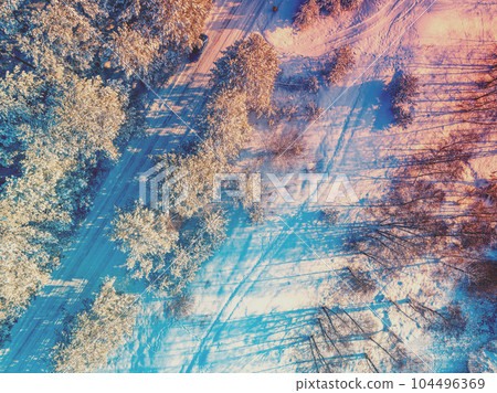 Winter landscape. Pine snowy forest. Trees covered with snow. Aerial view of the road in the winter pine forest Winter landscape. Pine snowy forest. Trees covered with snow. Aerial view of the road in the winter pine forest 104496369