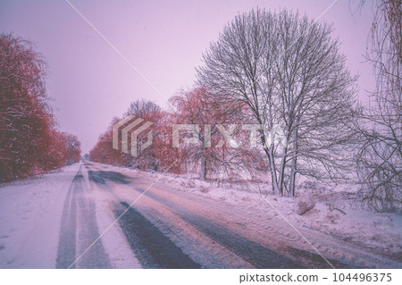 Winter country road. Winter rural landscape. The road in the early frosty morning. Landscape with the country road covered with snow. Winter travel concept Winter country road. Winter rural landscape. The road in the early frosty morning. Landscape with the country road covered with snow. Winter travel concept 104496375