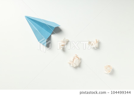 Paper plane and paper balls on white background Paper plane and paper balls on white background 104499344
