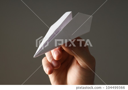 Male hand with paper plane on gray background Male hand with paper plane on gray background 104499366