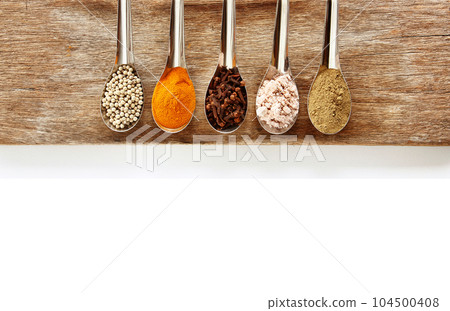 Spice and herbs in steel spoon are on wooden background. Displayed for the nutrients healthy banner. Spice and herbs in steel spoon are on wooden background. Displayed for the nutrients healthy banner. 104500408