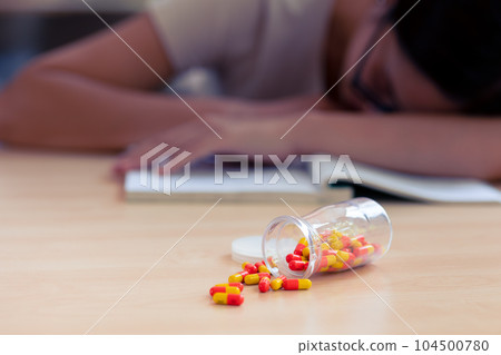 Young teen student with medicine drug capsule pill for pain relief or reduce stress from studying hard. Young teen student with medicine drug capsule pill for pain relief or reduce stress from studying hard. 104500780