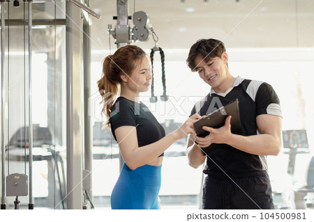 Healthy people asian young woman sport exercise in fitness gym sport club with personal trainer instructors help support. 104500981