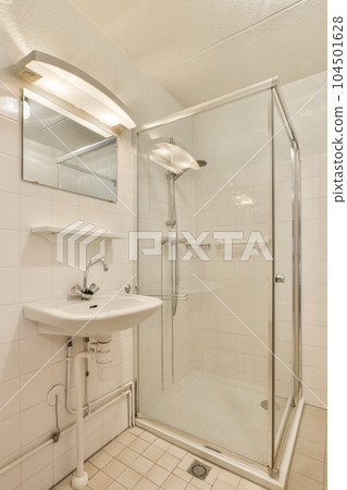 a bathroom with a sink, mirror and shower stall in the same room on the left side of the photo 104501628
