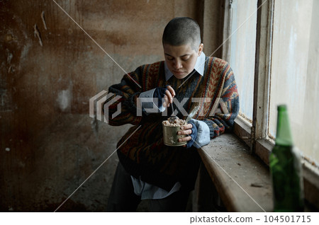 Poor homeless punk woman with sad look eating preserved food 104501715