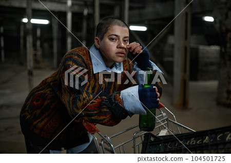 Portrait of unhappy drunk woman immigrant or beggar drinking beer Portrait of unhappy drunk woman immigrant or beggar drinking beer 104501725