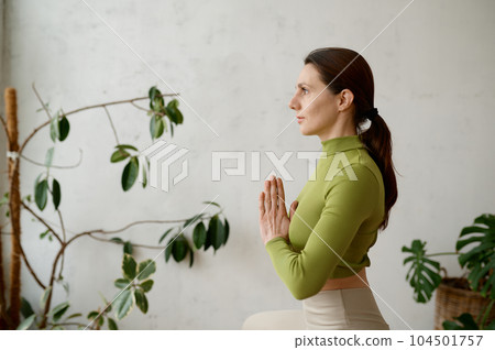 Side view portrait of young woman practicing yoga mindfulness technique 104501757