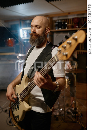 Portrait of handsome bearded guitarist of rock band playing guitar Portrait of handsome bearded guitarist of rock band playing guitar 104501776