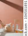 skincare and suncare with pestle and mortar and flower. horizontal with sunlight and shade. 104501891