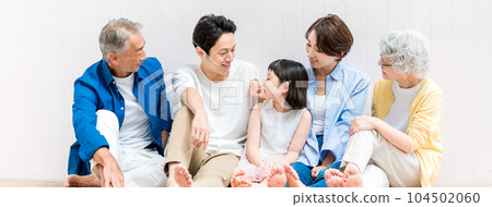A three-generation family sitting around a child 104502060