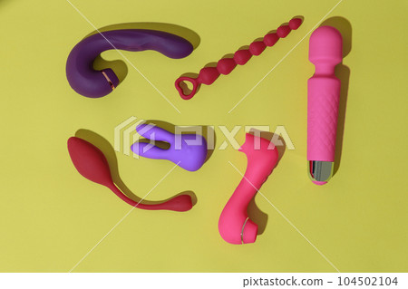 Top view of adult sex toys such as dildo, vibrator, buttplug on yellow background. Sex shop concept Top view of adult sex toys such as dildo, vibrator, buttplug on yellow background. Sex shop concept 104502104