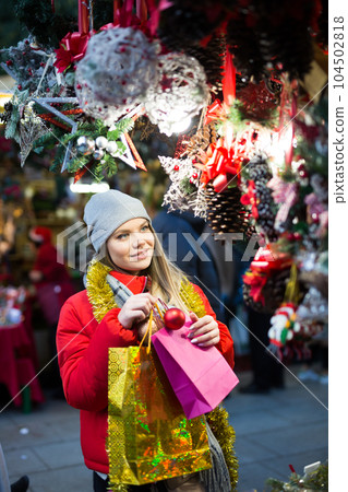Girl choosing Christmas gifts outdoor on street market Girl choosing Christmas gifts outdoor on street market 104502818