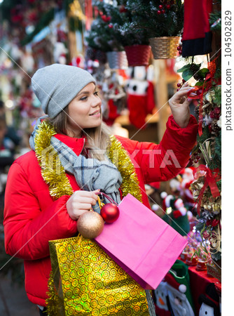Cheerful female customer with Christmas gifts on street Cheerful female customer with Christmas gifts on street 104502829