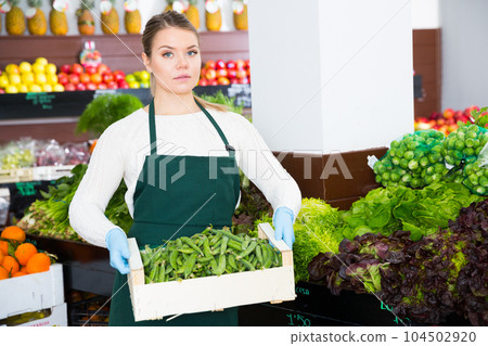 Salesgirl offering green beans 104502920
