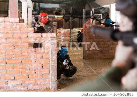 Players aim at the enemy behind barricades Players aim at the enemy behind barricades 104502995