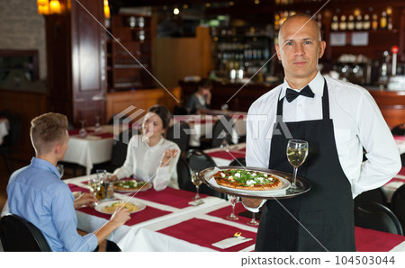 Waiter with serving tray meeting guests Waiter with serving tray meeting guests 104503044