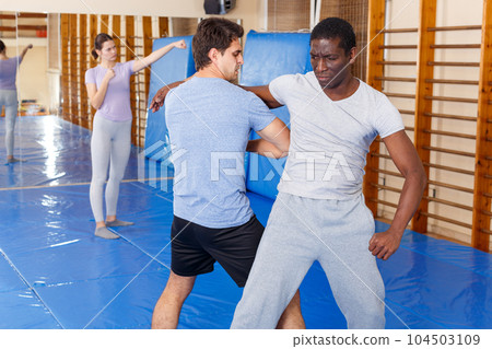 Two men practicing self defense techniques 104503109