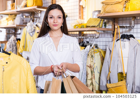 Woman carrying paper bags with purchases in clothes shop Woman carrying paper bags with purchases in clothes shop 104503125