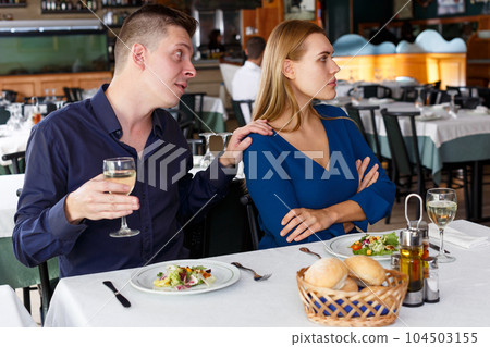 Upset man and woman quarreling in restaurant 104503155