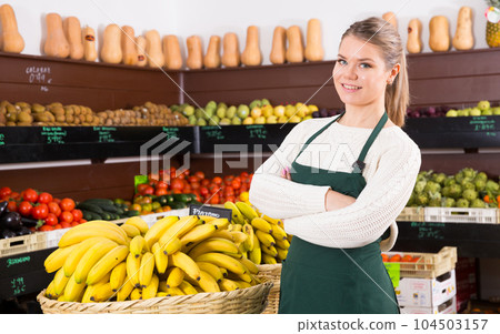 Woman in apron offering fresh vegetables and fruits on the market Woman in apron offering fresh vegetables and fruits on the market 104503157