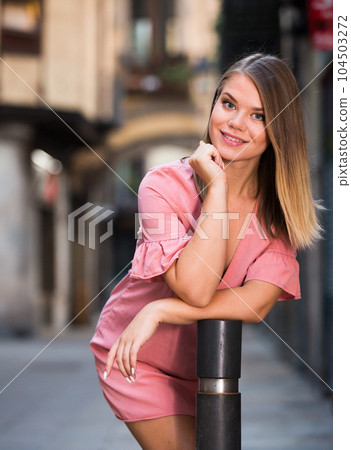 Positive female standing near column in historical center of Barcelona 104503272